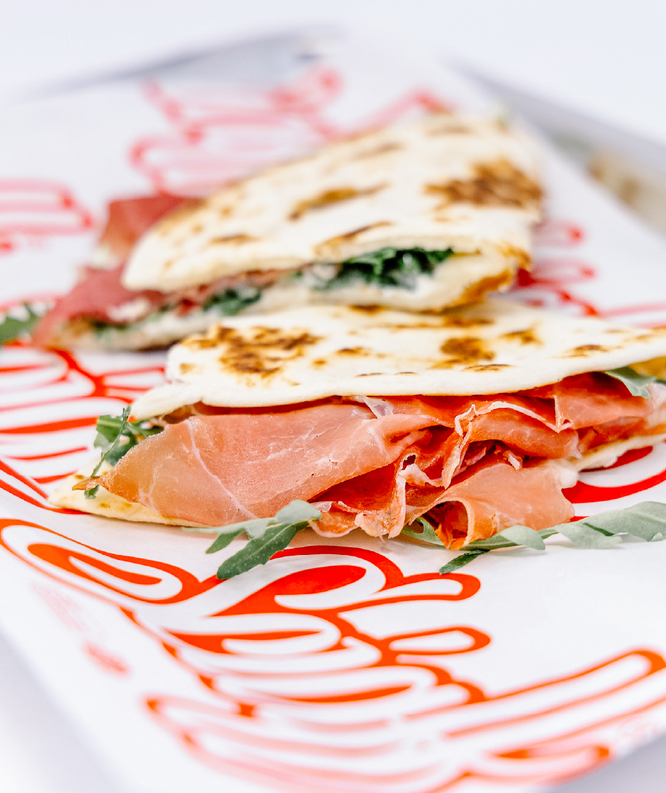 Piadina romagnola Sciaff con prosciutto crudo, squacquerone e rucola servita su vassoio brandizzato